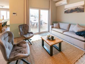 a living room with a couch and chairs and a table at Duplex Apartment in the shopping street of Maasmechelen in Maasmechelen