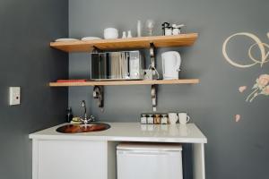 a kitchen counter with a sink and a microwave at Acorn Guest House in George