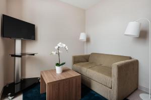ein Wohnzimmer mit einem Sofa und einem TV in der Unterkunft Exe Saldanha in Lissabon