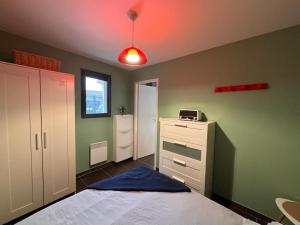 ein Schlafzimmer mit einem Bett und einer roten Lampe in der Unterkunft Le Studio de Vasconia in Muret