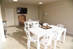 une salle à manger avec des tables et des chaises blanches dans l'établissement חאן דרך העץ - אוהל ממוזג וקמפינג, à Shadmot Devora