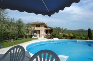 a swimming pool in front of a house at Agriturismo Il Crinale in Castorano