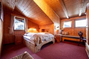 ein Schlafzimmer mit einem Bett in einer Holzhütte in der Unterkunft Panorama-Apartments Oberkofl in Steinhaus