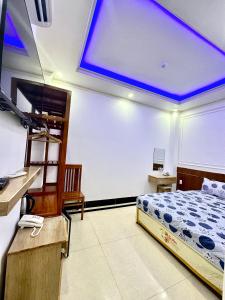 ein Schlafzimmer mit einem Bett mit blauer Decke in der Unterkunft Phụng Hoàng Vũ in Bạc Liêu