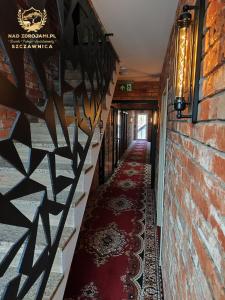 un pasillo de un edificio con alfombra roja en Szczawnica Residence "Nad Zdrojami" - In the Heart of Recreation 691-739-603 en Szczawnica