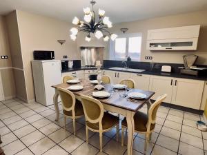 a kitchen with a wooden table and chairs in a kitchen at Château le Withof in Bourbourg