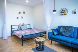 a living room with a bed and a couch at Jana's WoW apt, 2BR, Metro next door, near the airport in Prague