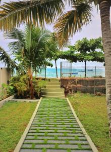 un conjunto de escaleras que conducen a la playa con palmeras en SHORE STORIES, en Alleppey