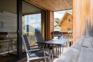 a dining room with a table and chairs on a balcony at Alpenresort B22 in Riederalp