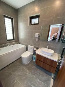 a bathroom with a tub and a toilet and a sink at KIÊN NGỌC VILLA Cat Ba in Cat Ba