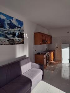 ein Wohnzimmer mit einem Sofa und einer Küche in der Unterkunft Appartamento vacanza il Picchio Rosso in Mantello