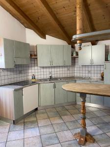 a kitchen with white cabinets and a wooden table at Cèsa Niki in Canazei