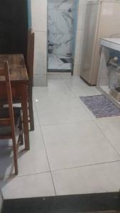 eine Küche mit einem Tisch und einem weißen Fliesenboden in der Unterkunft Casa Jabuticabeira in Ouro Preto
