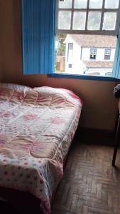 Bett in einem Zimmer mit Fenster in der Unterkunft Casa Jabuticabeira in Ouro Preto