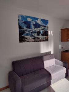 eine Couch in einem Wohnzimmer mit einem Gemälde an der Wand in der Unterkunft Appartamento vacanza il Picchio Rosso in Mantello