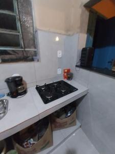 uma cozinha com um fogão e uma bancada branca em Casa Jabuticabeira em Ouro Preto
