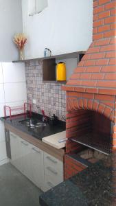 uma cozinha com um balcão com uma parede de tijolos em Shekinah em Sumaré