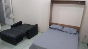een kamer met 2 bedden en een stoel. bij Shekinah in Sumaré