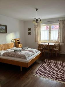 1 dormitorio con 1 cama, mesa y sillas en Chalupa Barbolica, en Vernár