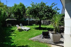 een tuin met twee stoelen en een palmboom bij Maison Roche Blanche in Port Blanc