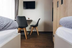 1 Schlafzimmer mit 2 Betten, einem Stuhl und einem TV in der Unterkunft Ubytování Kytín in Kytín