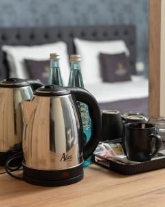 a tea kettle and two bottles on a table at Vetus Hotel in Pristina
