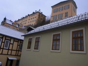 ein weißes Haus mit Fenstern und Gebäuden im Hintergrund in der Unterkunft Ferienhaus Rentsch in Rudolstadt