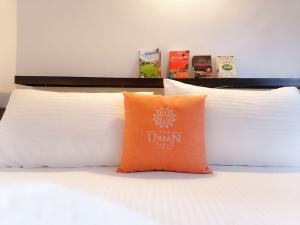 Urban Galle Villa في غالي: وسادة برتقالية موضوعة فوق السرير