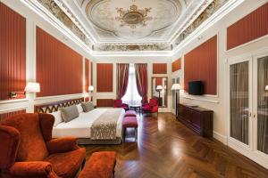 a bedroom with a bed and a couch and chairs at Catalonia Las Cortes in Madrid