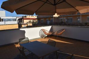a table and chairs on a balcony with umbrellas at Attic with terrace on Conca d'oro in Rome