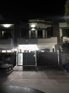 a large house with a black gate and a building at Sunrise Residence in Islamabad