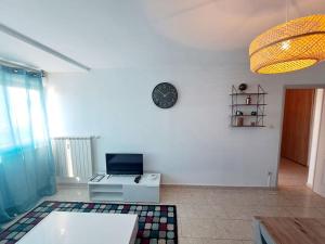 a living room with a clock on a white wall at Élégant - Hypercentre - Parking in Toulon