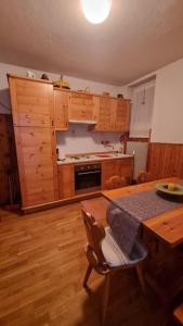 a kitchen with wooden cabinets and a wooden table with a table sidx sidx sidx at Trento, Monte Bondone, casa tipica di montagna in Norge