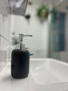 a black soap dispenser sitting on top of a counter at Modern studio in Barbican EC1 - blue - F4 in London