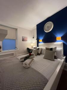 a bedroom with a large bed with a clock on the wall at Modern studio in Barbican EC1 - blue - F4 in London