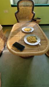 une table en osier avec deux assiettes de nourriture dans l'établissement The Aawargarh Retreat, à Jharol