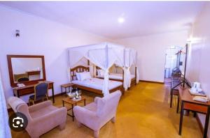 1 dormitorio con 1 cama con dosel en MACHAGE TOURS AND SAFARIS HOTEL en Karatu