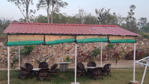 un groupe de tables et de chaises sous un kiosque dans l'établissement The Aawargarh Retreat, à Jharol