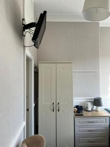 a kitchen with a white cabinet and a lamp at Y Garth Guesthouse in Bangor