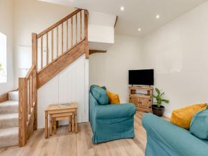 sala de estar con escalera y silla azul en The Barrels at Leintwardine en Leintwardine