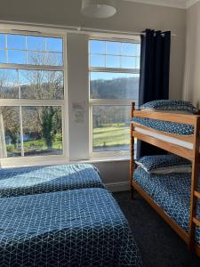 a bedroom with two beds and two windows at Y Garth Guesthouse in Bangor