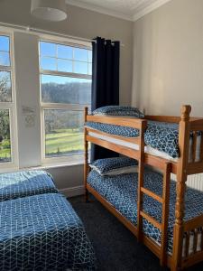 a bedroom with two bunk beds and a window at Y Garth Guesthouse in Bangor