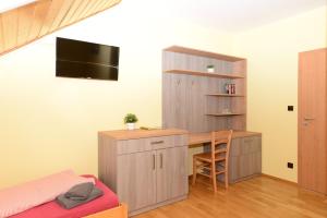 a room with a desk and a bed and a table at Podveský mlýn in Tlumačov