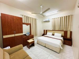 a bedroom with a bed and a couch at Bahla Jewel Hotel Apartments in Bahlāʼ