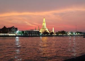 a view of a city from the water at night at Chaiwat Hostel in Bangkok