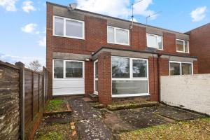 a brick house with white doors and a fence at 20% OFF Spacious Cosy Home with Free Parking in Exeter