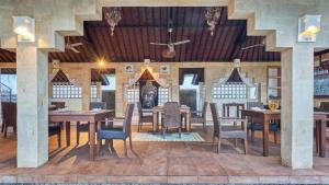 a dining room with wooden tables and chairs at Anda Amed Villas & Spa in Amed