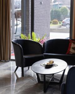 Vetus Hotel في بريشتيني: غرفة معيشة مع كرسيين وطاولة قهوة