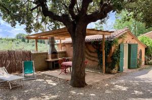 a house with a grill and a table and chairs at Agriturismo Fattoria La Prugnola in Montescudaio