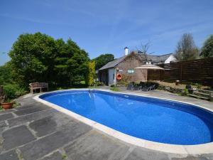 a large blue swimming pool in a yard at 3 Bed in Okehampton TCOAH in Broadwoodwidger